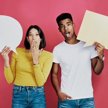 Image of 2 people with cardboard cutouts in form of question bubble